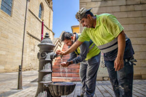 Unos trabajadores se refrescan este miércoles en una fuente en Logroño. EFE/Raquel Manzanares