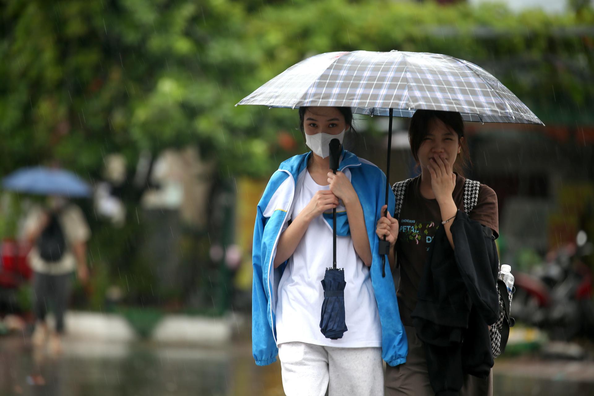 Dos personas bajo un paragüas en Vietnam por las lluvias del tifón Kajiki.
EFE/EPA/LUONG THAI LINH
