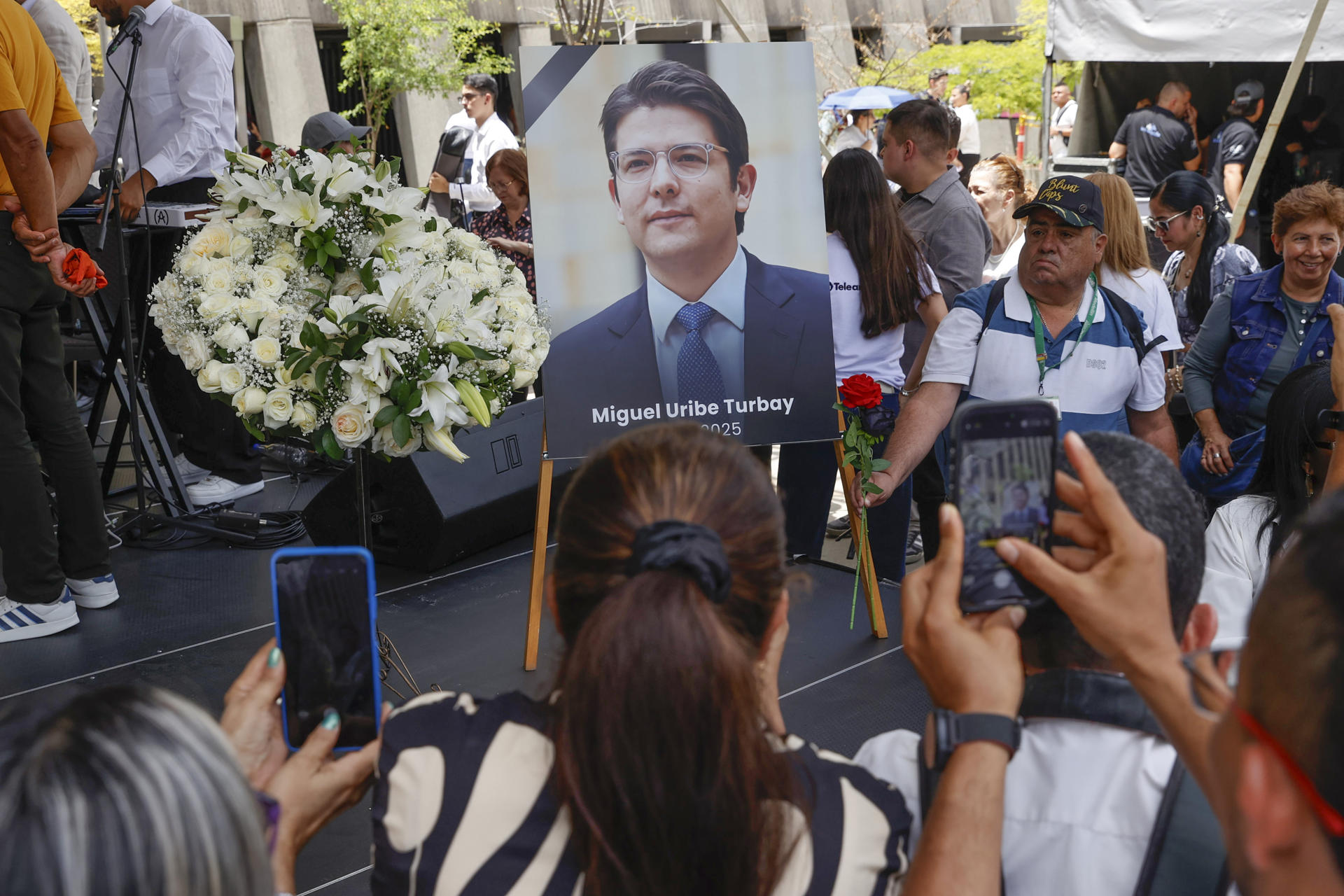 Personas toman fotografías a una imágen del fallecido senador y precandidato de Colombia Miguel Uribe Turbay, durante un homenaje este martes. EFE/ Mauricio Dueñas Castañeda