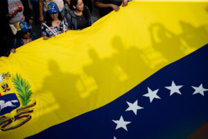 Personas sostienen una bandera de Venezuela en Caracas, en una fotografía de archivo. EFE/ Ronald Peña R