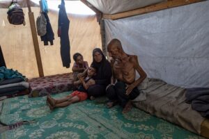 El anciano palestino desplazado internamente Salim Asfour (d) junto a su familia e una tienda de campaña en Jan Yunis, en la Franja de Gaza sur, el 3 de agosto de 2025. EFE/EPA/HAITHAM IMAD