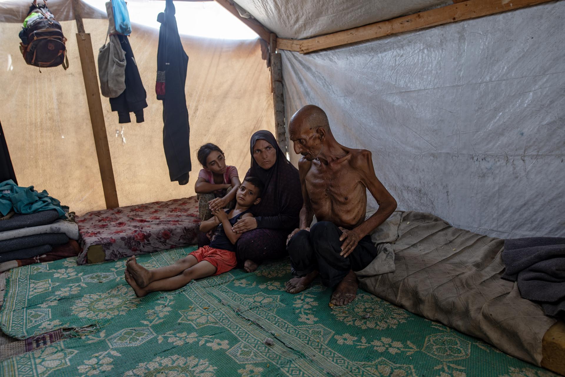 El anciano palestino desplazado internamente Salim Asfour (d) junto a su familia e una tienda de campaña en Jan Yunis, en la Franja de Gaza sur, el 3 de agosto de 2025. EFE/EPA/HAITHAM IMAD