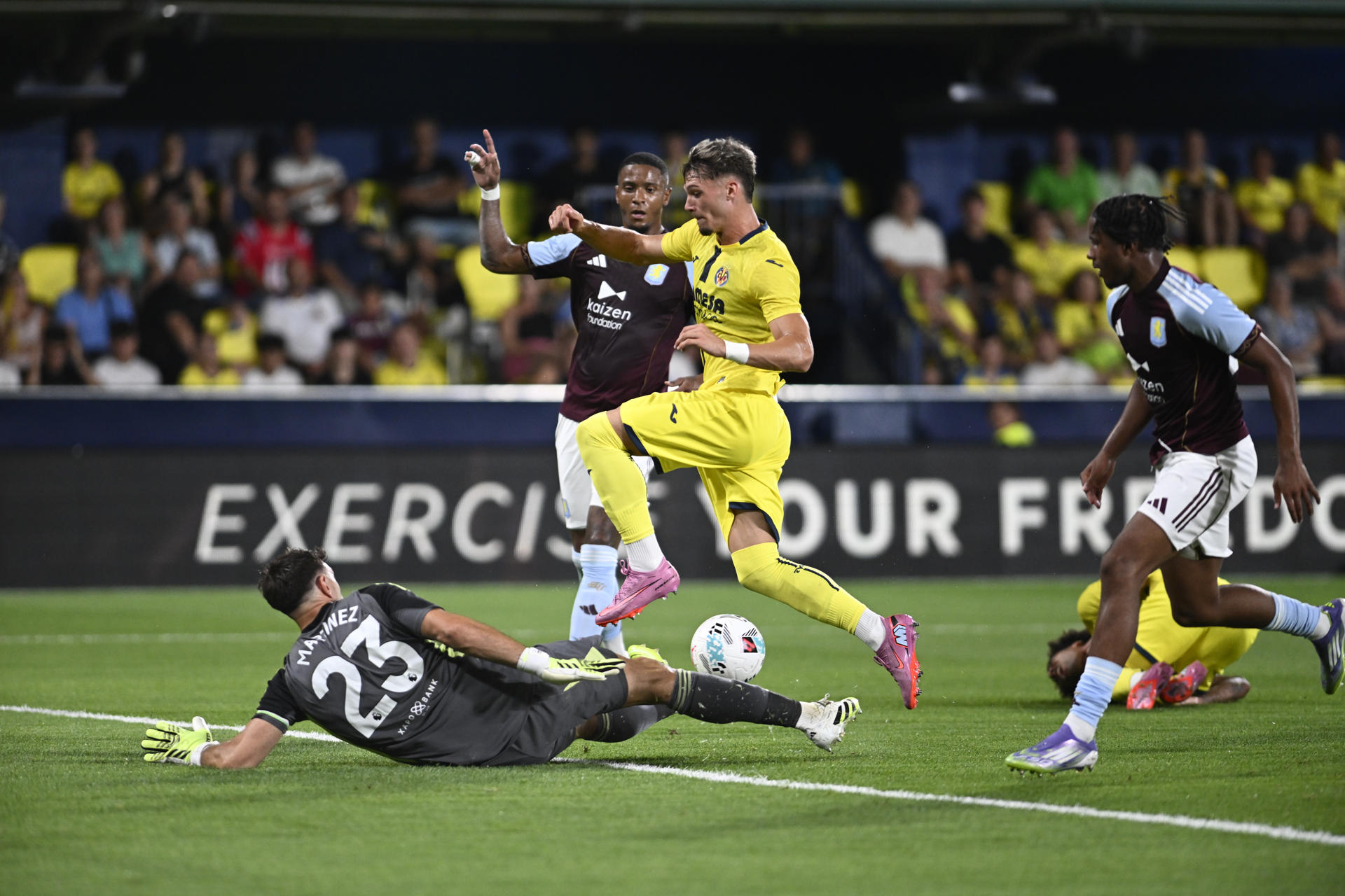 El delantero del Villarreal Pau Cabanes (c) intenta superar a Emiliano Martínez (i), guardameta del Aston Villa, en foto de archivo de Andreu Esteban