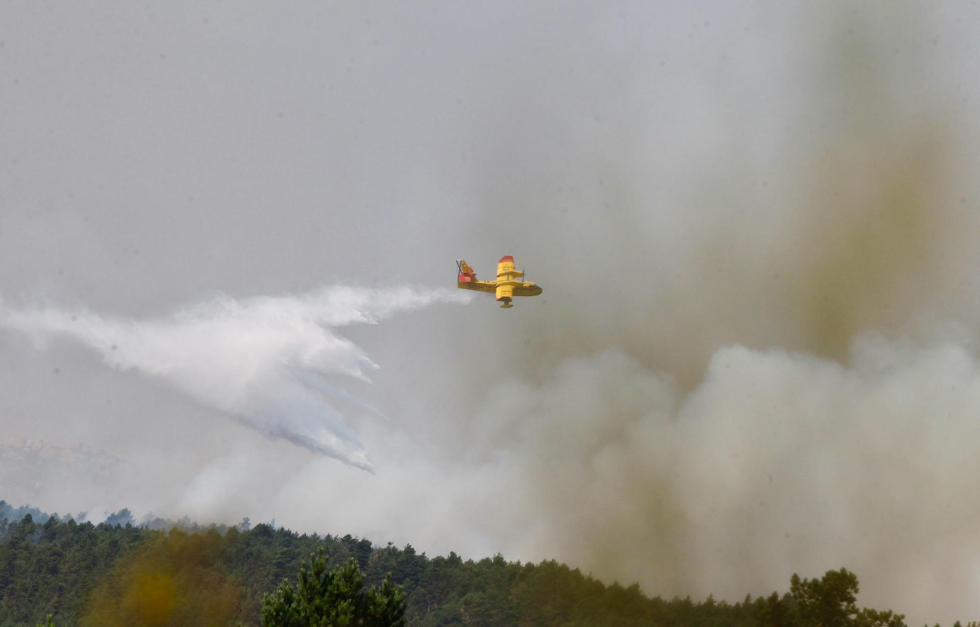 Los hidroaviones hacen descargas para intentar que el incendio de Ourense no baje la ladera y llegue a Castromil (Zamora). EFE/Mariam A. Montesinos
