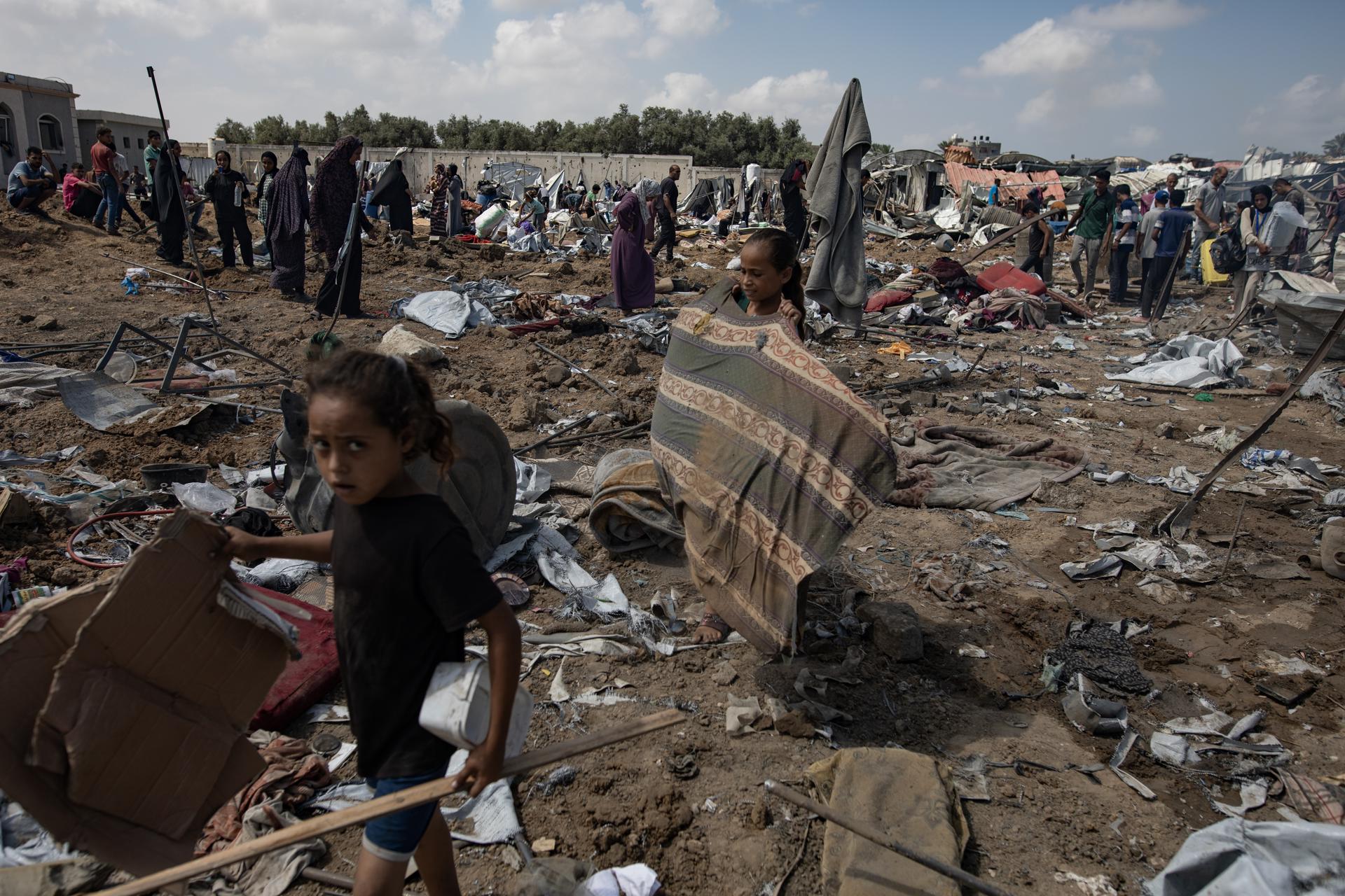 Refugiados palestinos inspeccionan tiendas de campaña destruidas después de un ataque israelí en el campamento de Al-Manasrah, que albergaba a más de 200 familias en Deir al-Balah, en la Franja de Gaza central, 21 de agosto de 2025. EFE/EPA/HAITHAM IMAD
