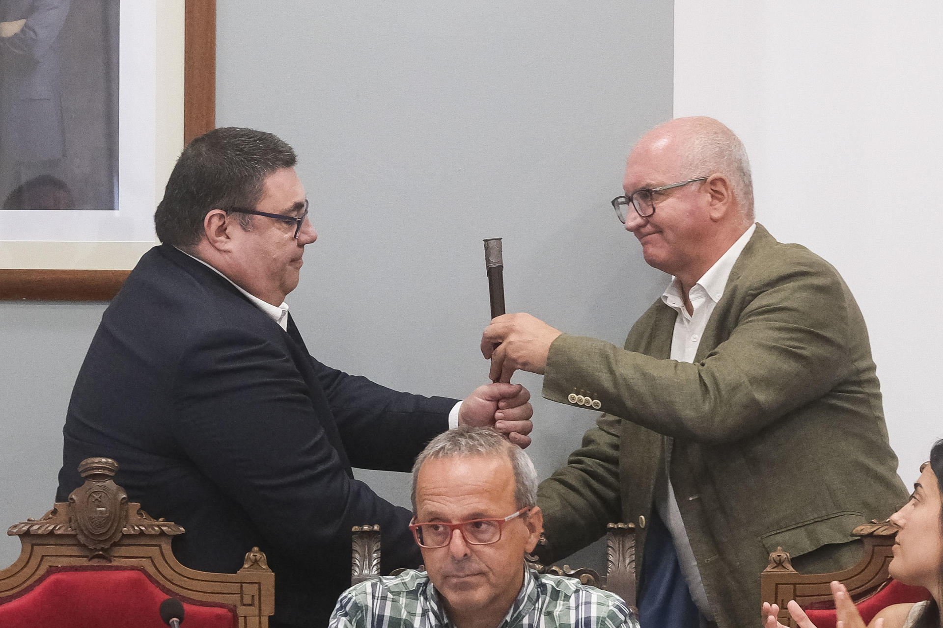 Santiago Freire (PP) (d), regidor saliente de Noia (A Coruña), entrega el bastón de mando al socialista Francisco Pérez Caamaño (i) tras la moción de censura en la que este último ha sido proclamado nuevo alcalde del municipio. Freire (PP) llevaba al frente del ayuntamiento desde el año 2016. EFE/Xurxo Martínez