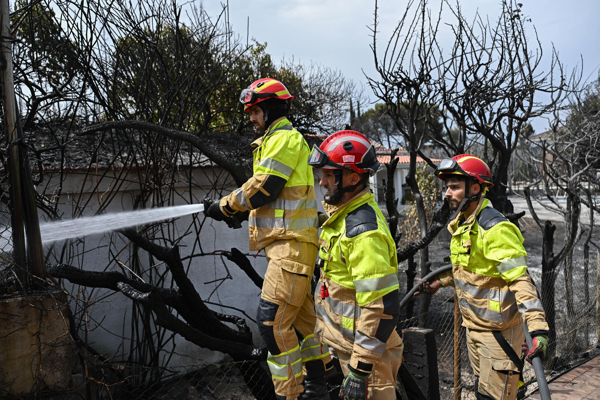 Bomberos en labores de extinción del incendio que desde ayer afecta a la localidad de Tres Cantos, Madrid, que ya está perimetrado y evoluciona favorablemente. EFE/Fernando Villar