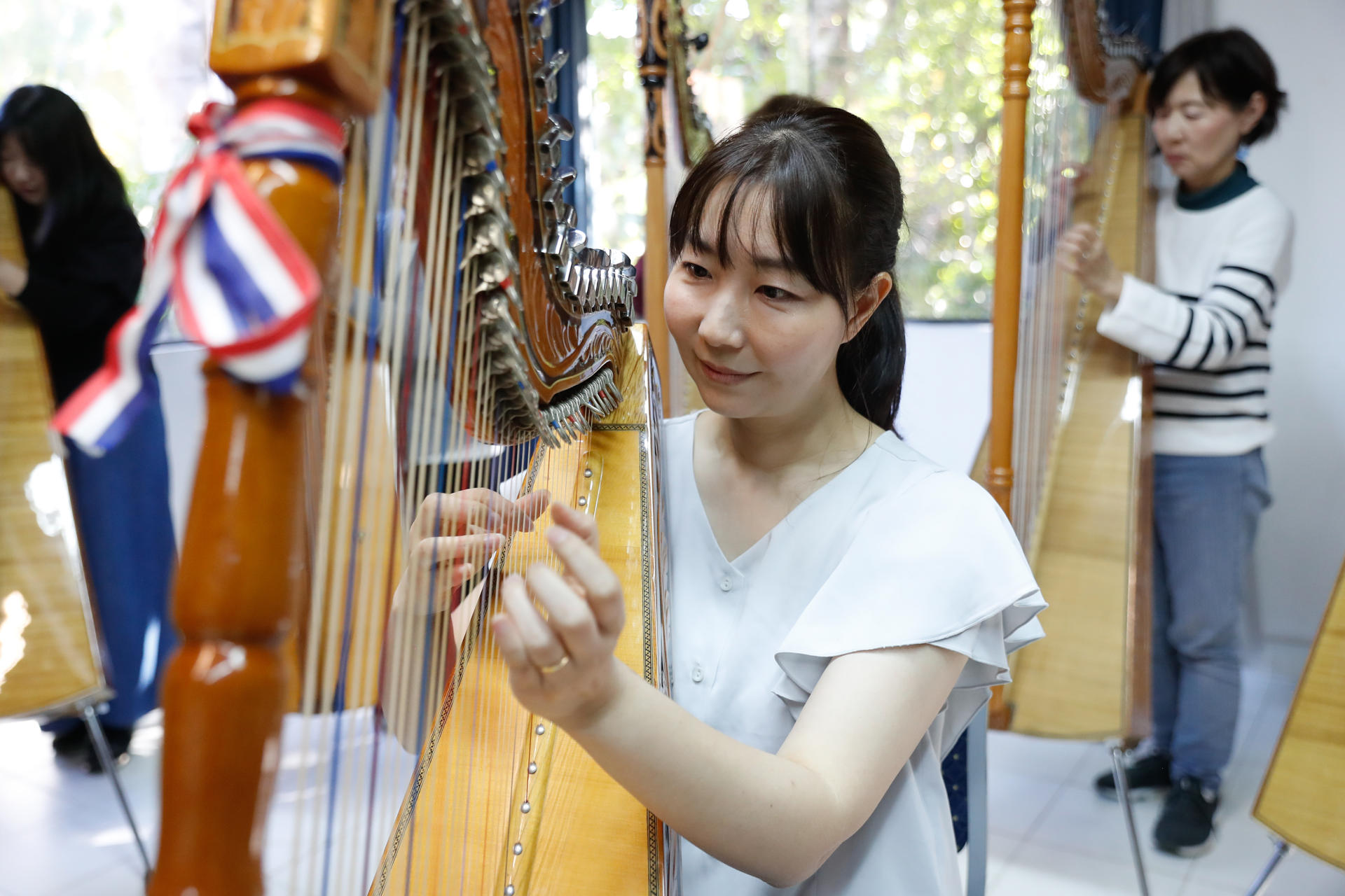 Fotografía del 12 de agosto de 2025 de la profesora de arpa de la escuela Arpas Estudio Sonrisa, Arisa Matsuki, durante un ensayo en Asunción (Paraguay). EFE/ Juan Pablo Pino