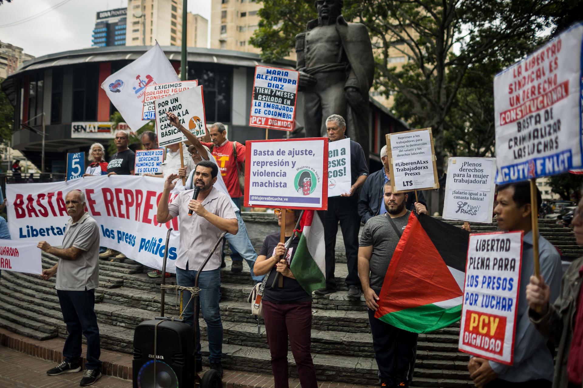 Personas sostienen carteles durante una manifestación este jueves, en Caracas (Venezuela). EFE/ Miguel Gutierrez
