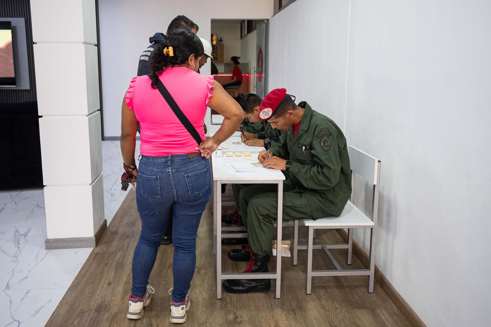 Una mujer se registra durante una jornada de alistamiento de la Milicia Nacional Bolivariana en las instalaciones del Cuartel de la Montaña 4F este domingo, en Caracas (Venezuela). EFE/ Ronald Pena R