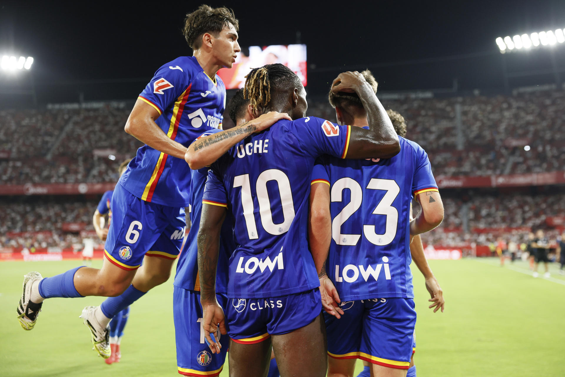 El delantero del Getafe Adrián Liso (d) celebra con sus compañeros tras marcar el 0-1 durante el partido correspondiente a la segunda jornada de LaLiga EA Sports entre Sevilla y Getafe disputado en el estadio Sánchez Pizjuán de Sevilla. EFE/José Manuel Vidal