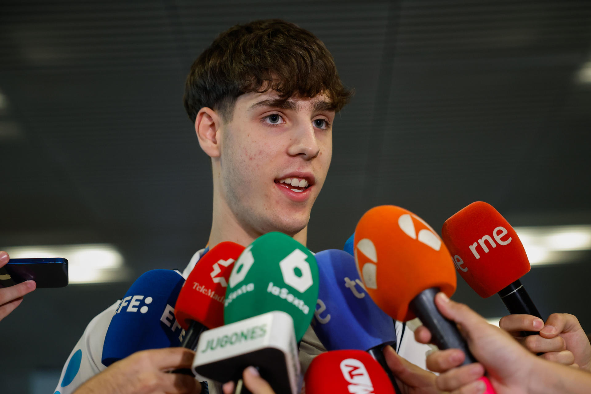 Guillermo del Pino ofrece declaraciones a su llegada este lunes, al aeropuerto de Madrid Barajas de la capital española. La selección española sub-18 de baloncesto se proclamó ayer campeona de Europa tras vencer a la selección francesa en la final del U18 Eurobasket 2025. EFE/ Mariscal

