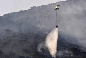 .- Un helicóptero trabaja en las labores de extinción del incendio que desde ayer afecta a la Sierra de la Plata, en Tarifa (Cádiz). EFE/Román Ríos