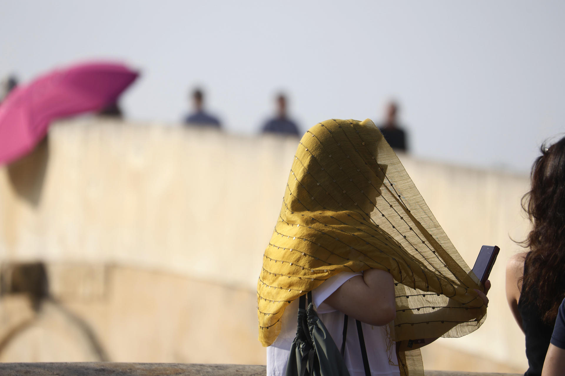 Una turista se cubre la cabeza con un pañuelo mientras camina por el Puente Romano de Córdoba, este martes. EFE/Salas