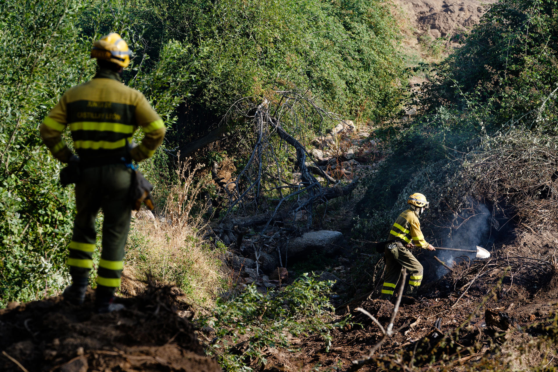Unos miembros de una cuadrilla trabajan en uno de los puntos calientes del incendio de Las Navas del Marqués (Ávila), este domingo. El incendio que el viernes se declaró en el municipio abulense de San Bartolomé de Pinares y se extendió a Las Navas del Marqués se encuentra en una situación "favorable", después de una noche en la que han seguido produciéndose "pequeñas reactivaciones" en el interior del perímetro, que han sido controladas. EFE/ Raúl Sanchidrián