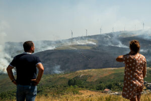 Varias personas observan el incendio forestal declarado ayer en Avión (Ourense), este lunes. EFE/Brais Lorenzo