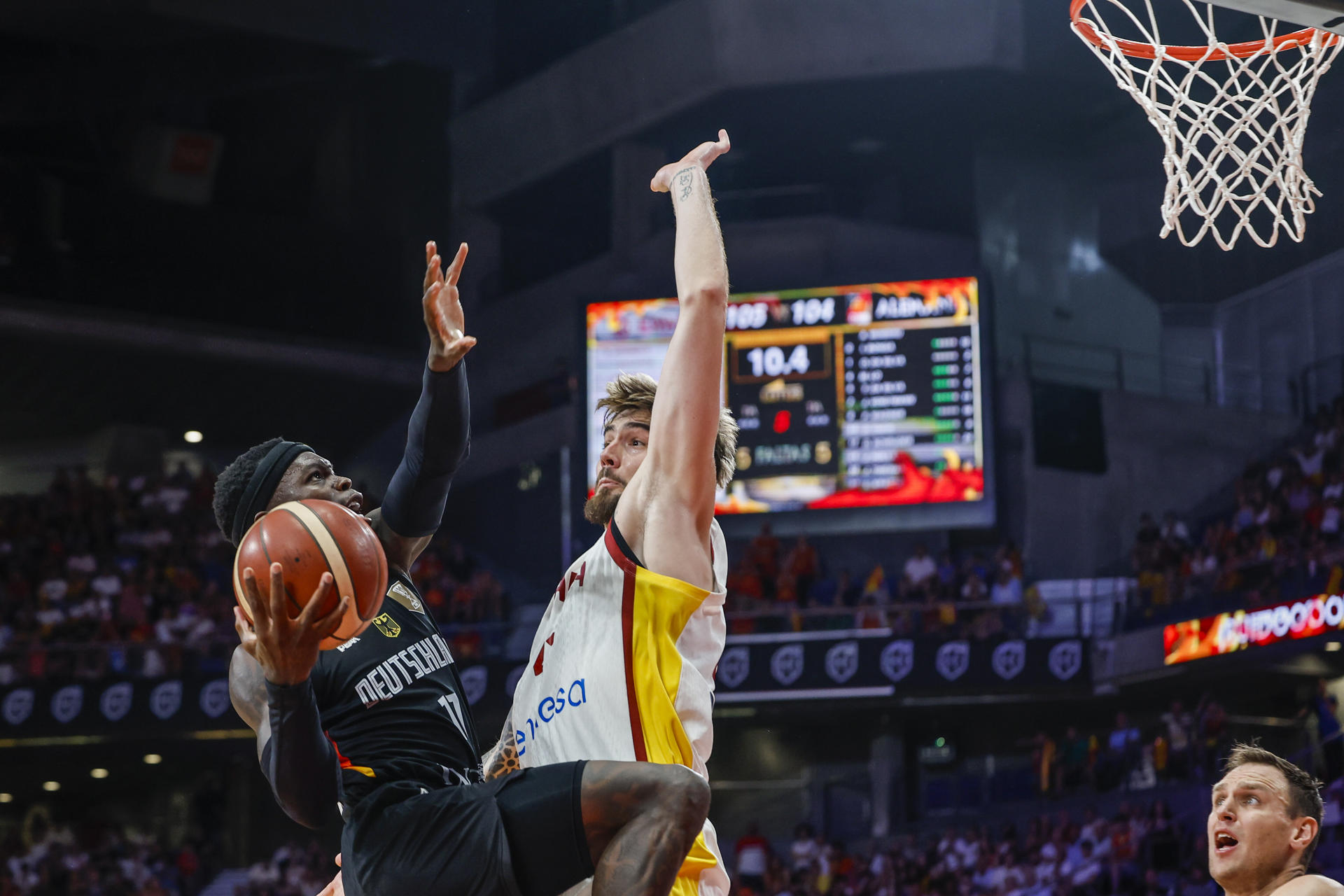 El base de la selección alemana de baloncesto Dennis Schroeder (i) entra a canasta ante Juancho Hernangómez, durante el partido amistoso que España y Alemania han disputado este jueves en el Madrid Arena. EFE/Mariscal
