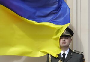 KYIV (Ukraine), 24/08/2025.- Un soldado rinde honores junto a una bandera de su país en el 34 aniversario de la Independencia de Ucrania. (Ucrania, Kiev) EFE/EPA/SERGEY DOLZHENKO