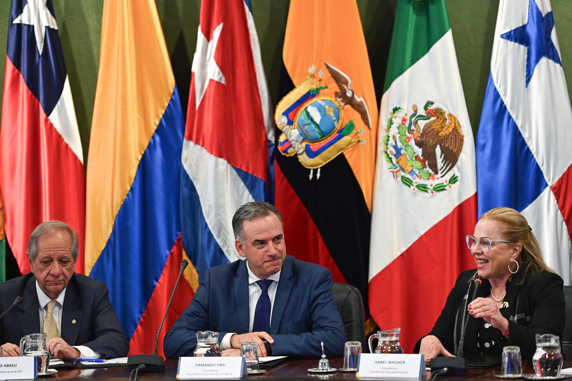 El secretario general de la Asociación Latinoamericana de Integración (Aladi), Sergio Abreu (i), el presidente de Uruguay, Yamandú Orsi, y la presidenta del Cómite de Representantes, Isabel Wagner, hablan durante la celebración del 45° aniversario de la Aladi este viernes, en Montevideo (Uruguay). EFE/ Federico Gutiérrez
