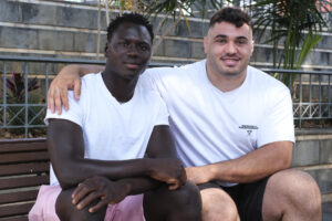 Lamine Dieng (Senegal, 2008) ( i) y Eusebio Ledesma (Santa Cruz de Tenerife, 1996) (d) nacieron a 1.600 kilómetros de distancia, separados por un océano de diferentes realidades, pero las casualidades del destino han hecho que este año ambos hundieran sus pies sobre la misma arena para lograr que el Club de Lucha Chimbesque se alzara como campeón de Canarias por primera vez en sus 36 años. EFE/Alberto Valdés