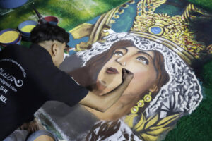 Un artesano trabaja con figuras y flores de aserrín la imagen de la Virgen de la Caridad en la tradicional 'Noche que Nadie Duerme' este viernes, en Huamantla (México). EFE/ Hilda Ríos