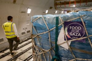 Un trabajador se encuentra junto a cajas con ayuda humanitaria de la iniciativa 'Alimentos para Gaza' durante los preparativos para su envío en un avión de transporte en el Aeropuerto de Fiumicino, en Roma, Italia, el 8 de agosto de 2025. (Italia, Roma) EFE/EPA/FABIO FRUSTACI