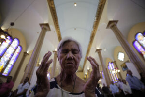 Fotografía de archivo de una mujer al orar en la Basílica de Suyapa, en Tegucigalpa (Honduras). EFE/Gustavo Amador