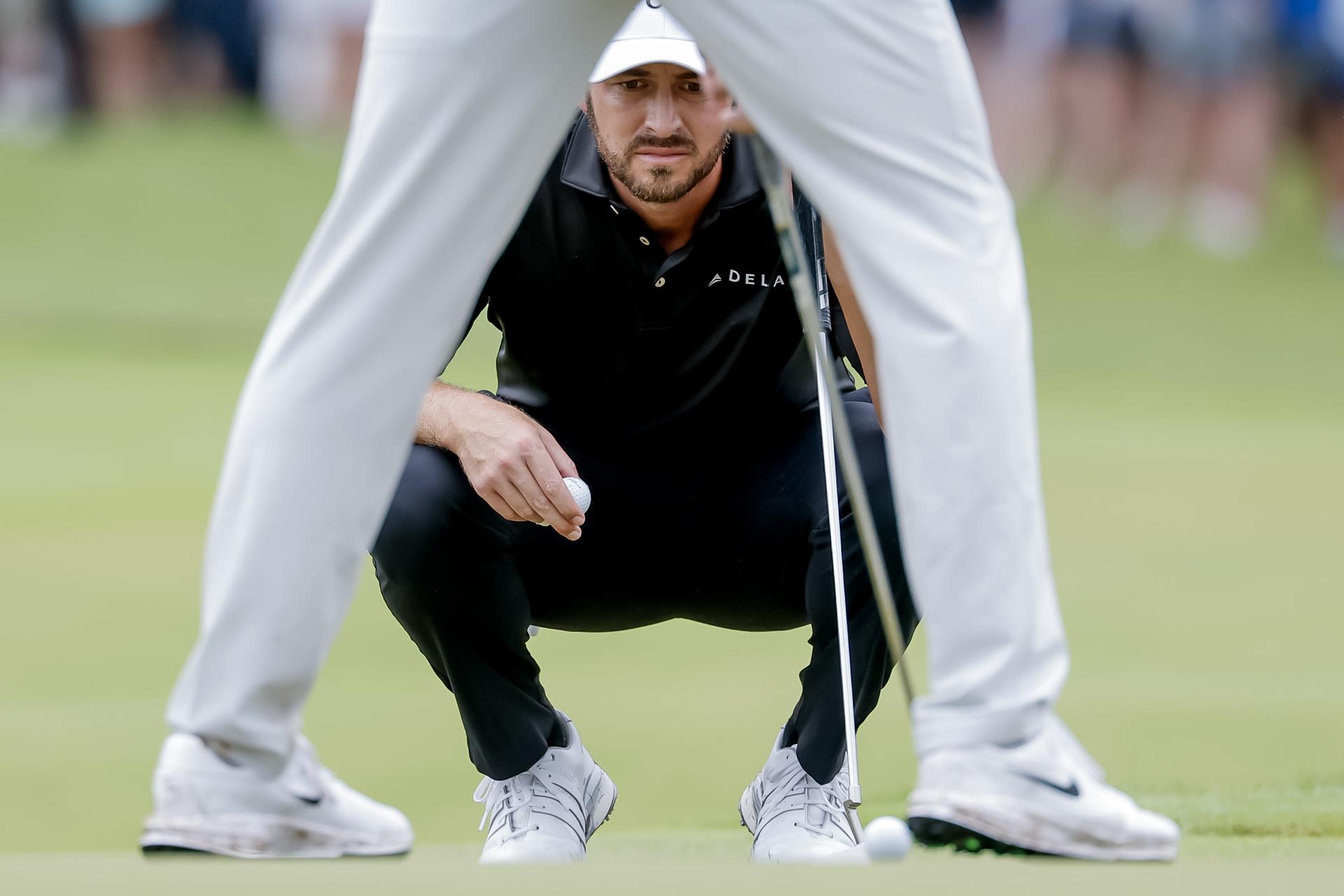 Patrick Cantlay de EE.UU. espera a que Scottie Scheffler de EE.UU. ponga la bola en el hoyo cinco durante la tercera ronda del torneo de golf Tour Championship 2025. EFE/EPA/ERIK S. LESSER