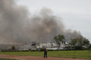 Una persona observa un incendio este domingo, en el Parque Industrial Logístico Nuestra Señora de la Asunción, en Luque (Paraguay). EFE/ Juan Pablo Pino