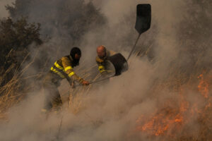 Dos voluntarios realizan labores de extinción en el incendio de Oímbra (Ourense) este martes. EFE/ Brais Lorenzo