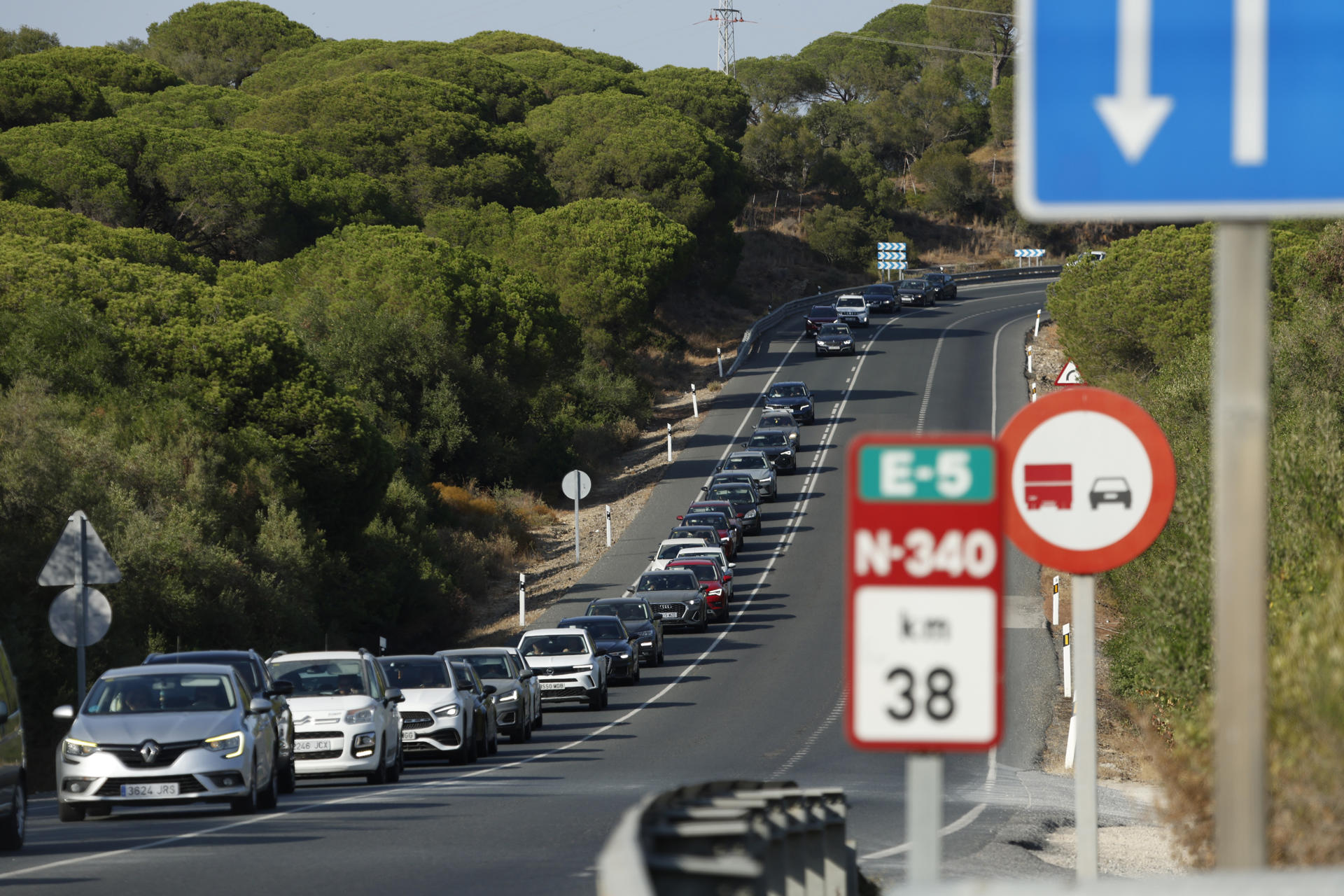 Coches en caravana que han sido desalojados de Zahara de los Atunes, mientras los efectivos del Infoca trabajan en la extinción del incendio declarado en la sierra de la Plata, cerca de la playa de Bolonia en Tarifa (Cádiz), para el que se ha activado esta tarde la fase de emergencia, situación operativa 1, según ha informado en sus redes sociales el consejero andaluz Antonio Sanz. EFE/A.Carrasco Ragel.
