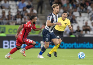 Sergio Canales (c), del Monterrey, disputa el balón con Jordan Sierra, del Mazatlan, este domingo durante un partido del Torneo Apertura 2025 de México. EFE/Miguel Sierra