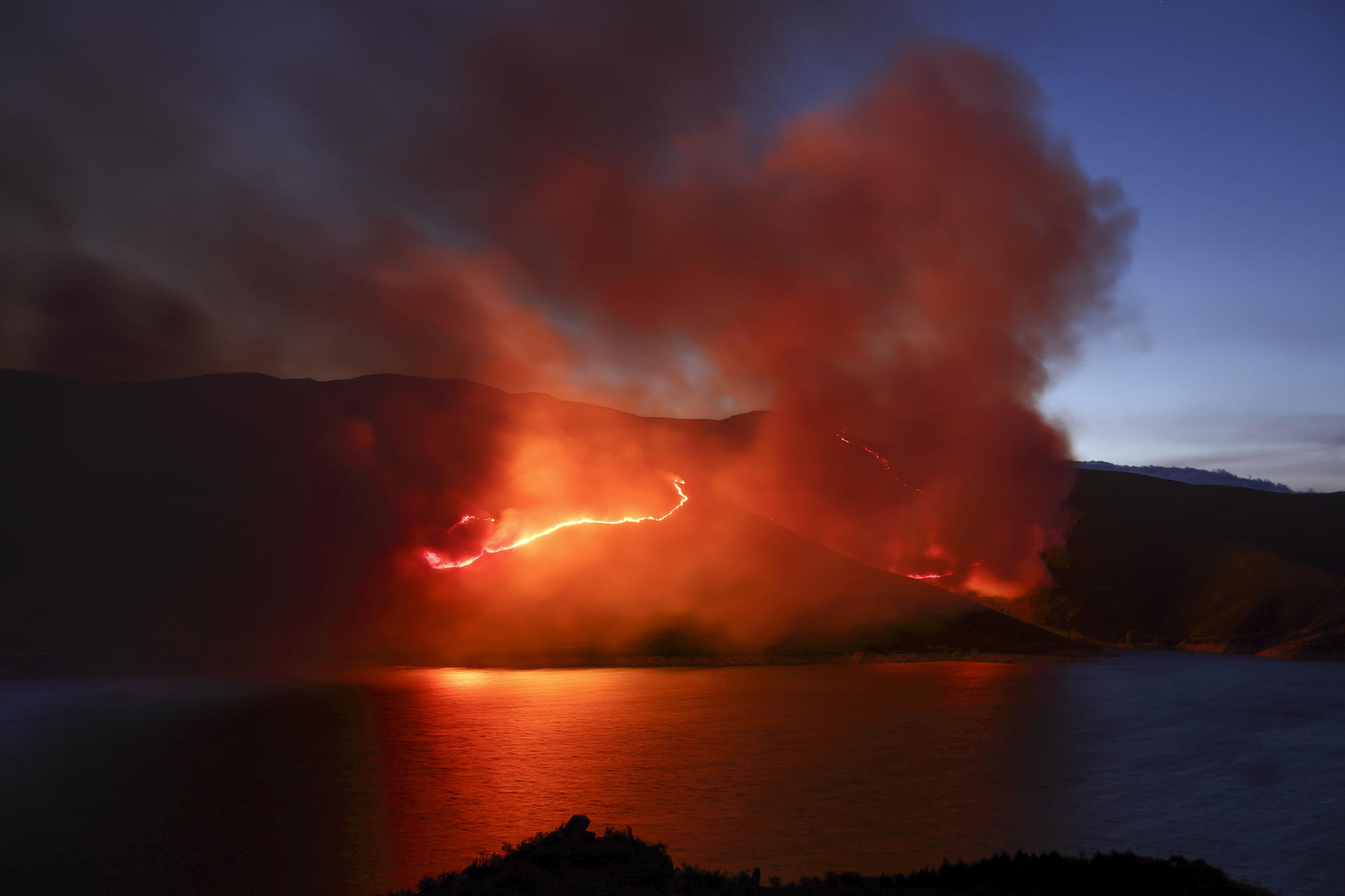 Incendio que se originó en Chendrexa de Queixa a su llegada en la noche de este miércoles a la localidad de Vilariño de Coso, en Ourense. EFE/Sxenick
