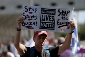 Un hombre sostiene una pancarta que reza: 'Dejad de matar de hambre a Gaza. Las vidas de los palestinos importan. Parad el genocidio' durante una manifestación convocada en Jerusalén, este sábado, para exigir un acuerdo que permita liberar a los rehenes que aún permanecen en la Franja de Gaza. Varios grupos de manifestantes israelíes bloquearon este domingo algunas de las principales autopistas de Israel para exigir un acuerdo que permita liberar a los rehenes que aún permanecen en la Franja de Gaza. Esta mañana, en una rueda de prensa para dar comienzo a la huelga, algunos familiares de secuestrados y de asesinados en los ataques de Hamás del 7 de octubre pidieron al Gobierno israelí un acuerdo completo, que libere a todos los rehenes en el enclave y ponga fin a la guerra en Gaza. EFE/ Atef Safadi