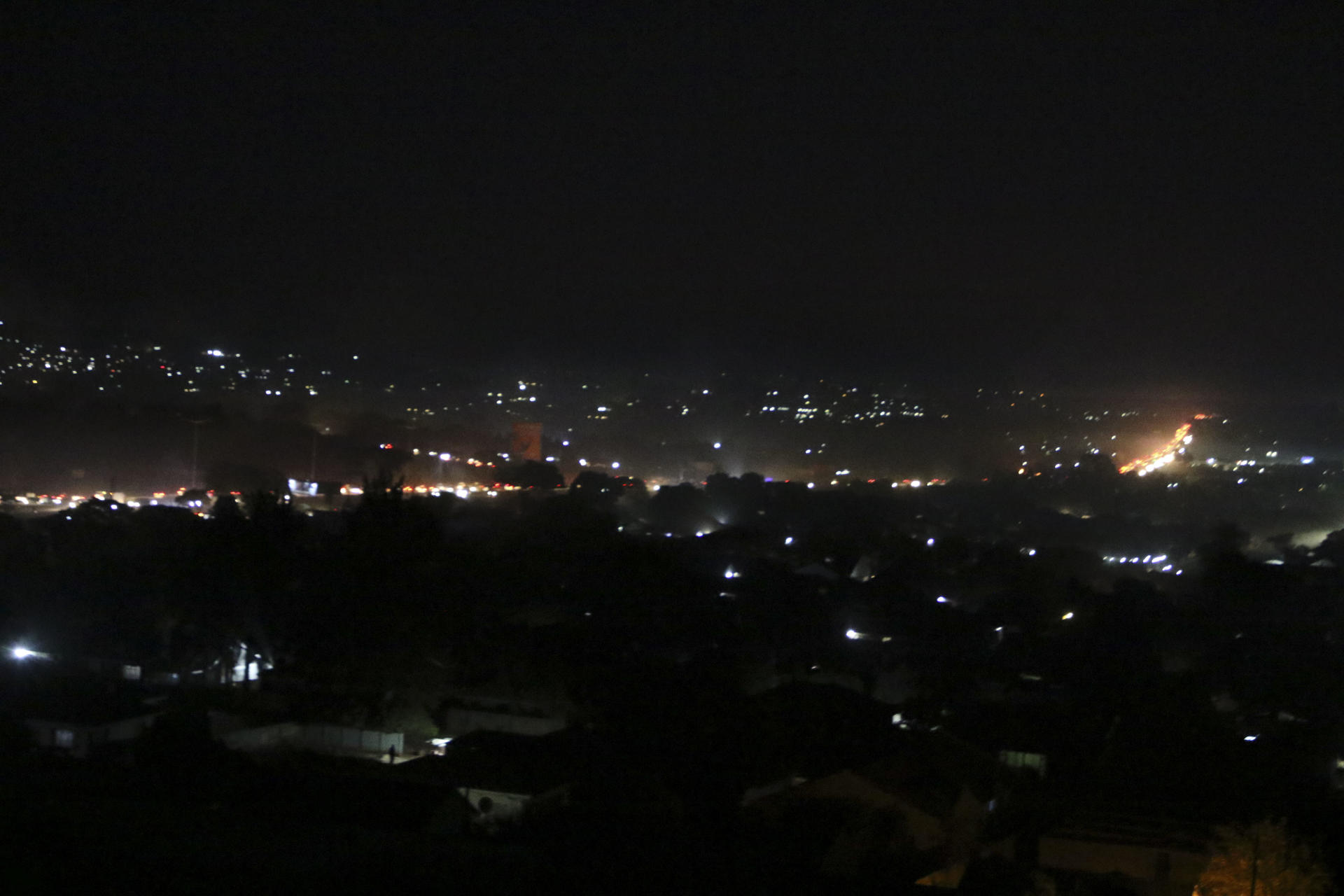 La ciudad de Harare, capital de Zimbabue, iluminada por los generados eléctricos de hogares y comercios zimbabuenses, que desde hace años atraviesan apagones diarios que pueden durar hasta 14 horas. EFE/Chengetai Zvauya
