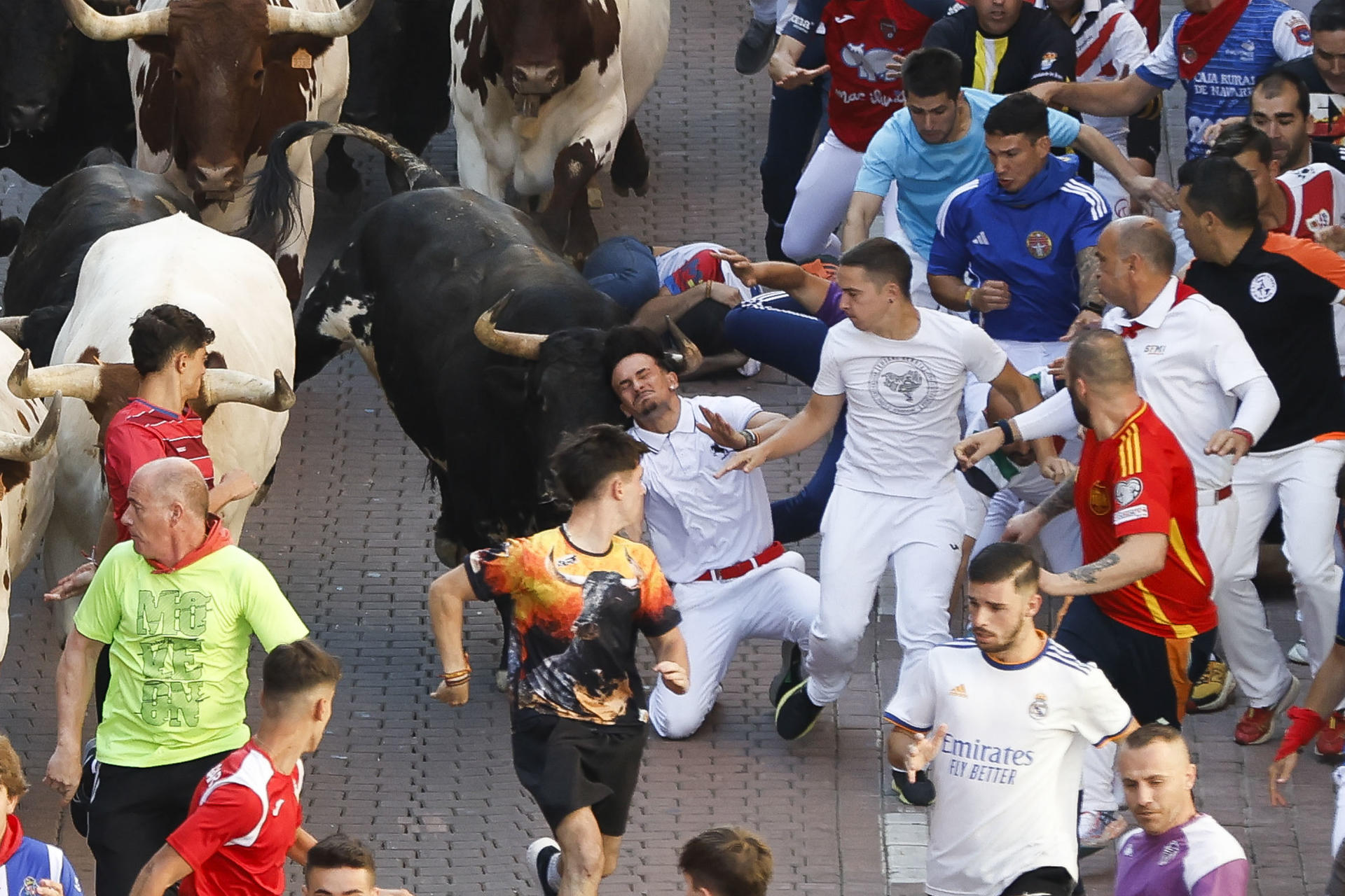 Los corredores son perseguidos por los toros durante el quinto encierro de San Sebastián de los Reyes este jueves. EFE/ David Fernández