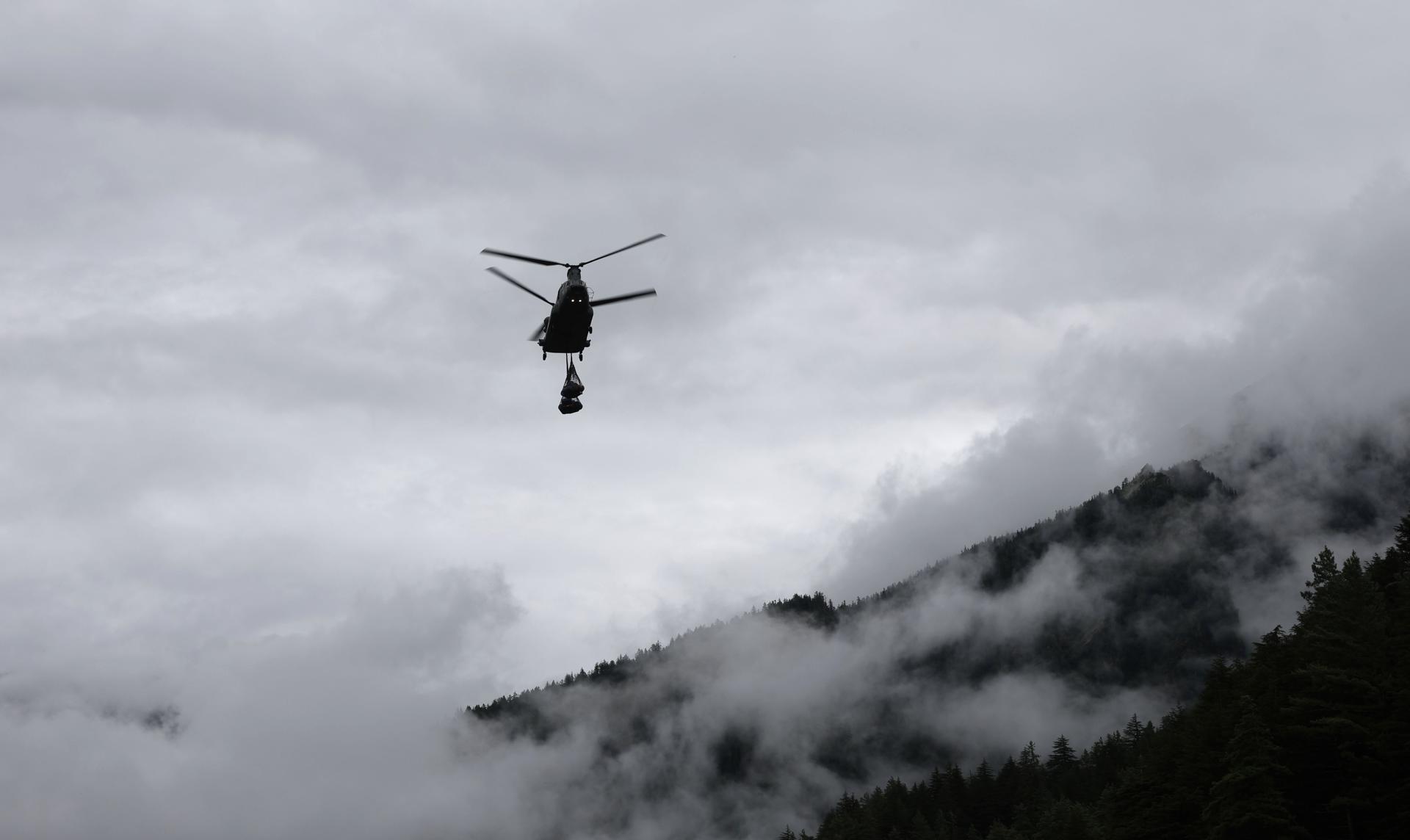 Un helicóptero Chinook de la Fuerza Aérea India transporta material de socorro durante la misión de rescate en Harshil tras el aguacero que azotó la aldea de Dharali, en el distrito de Uttarkashi, estado de Uttarakhand, norte de la India, el 14 de agosto. EFE/EPA/RAJAT GUPTA
