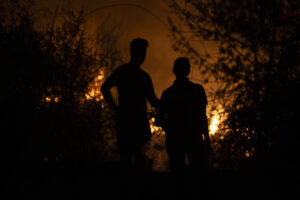 Dos personas observan la evolución del incendio forestal en A Rúa (Ourense). EFE/ Brais Lorenzo