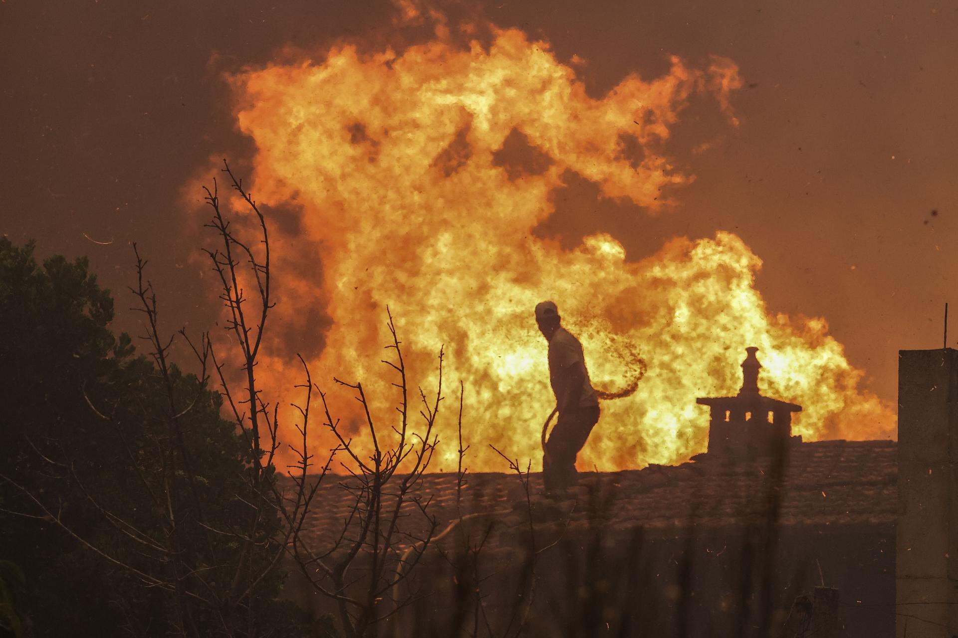 Un lugareño intenta apagar un fuego del incendio declarado en Lourical do Campo, cerca de Castelo Branco, en Portugal. EFE/PAULO NOVAIS
