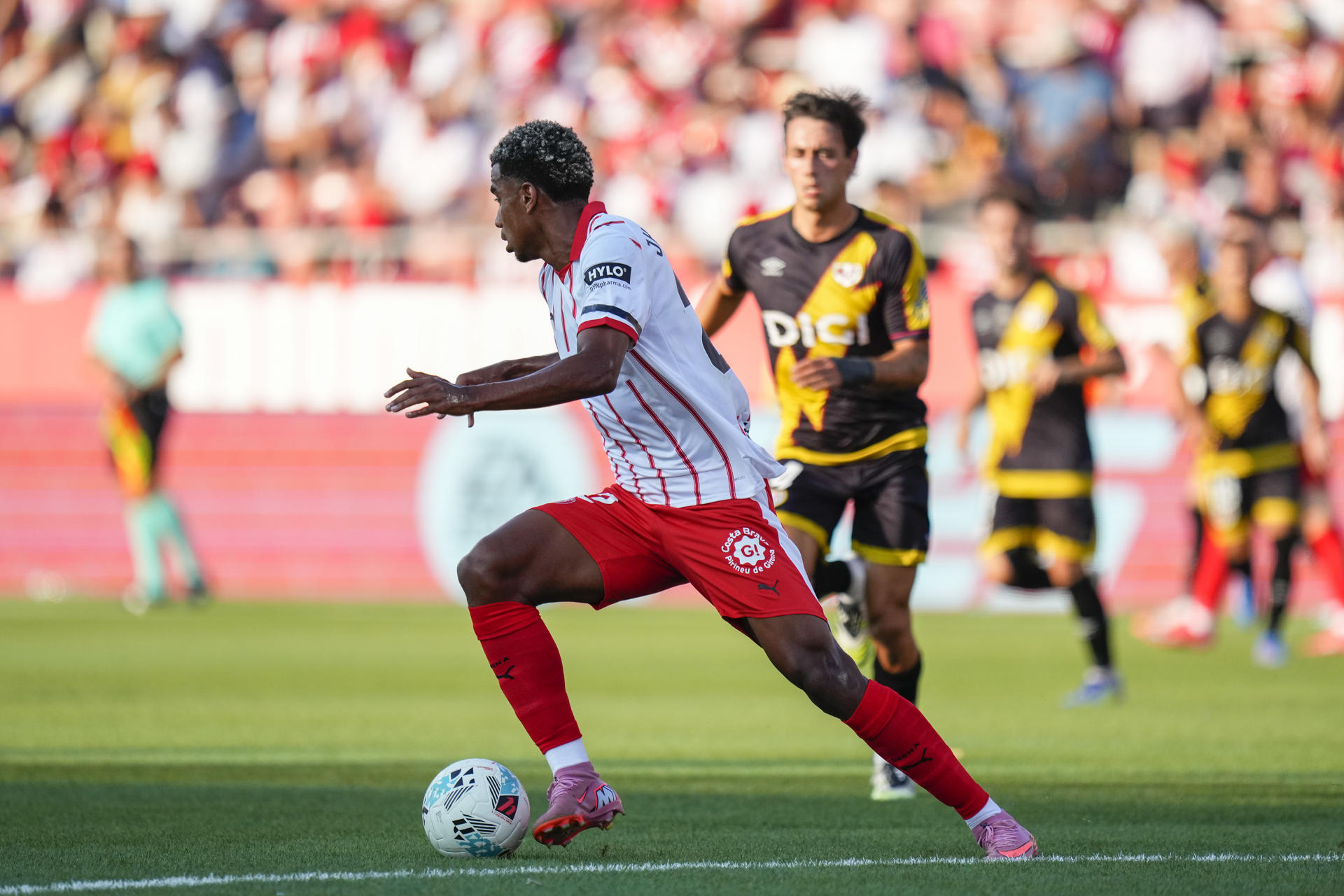 El centrocampista colombiano del Girona Jhon Solis se escapa con el balón durante el partido de la primera jornada de LaLiga que Girona CF y Rayo Vallecano disputan este viernes en el estadio Municipal de Montilivi. EFE/Siu Wu
