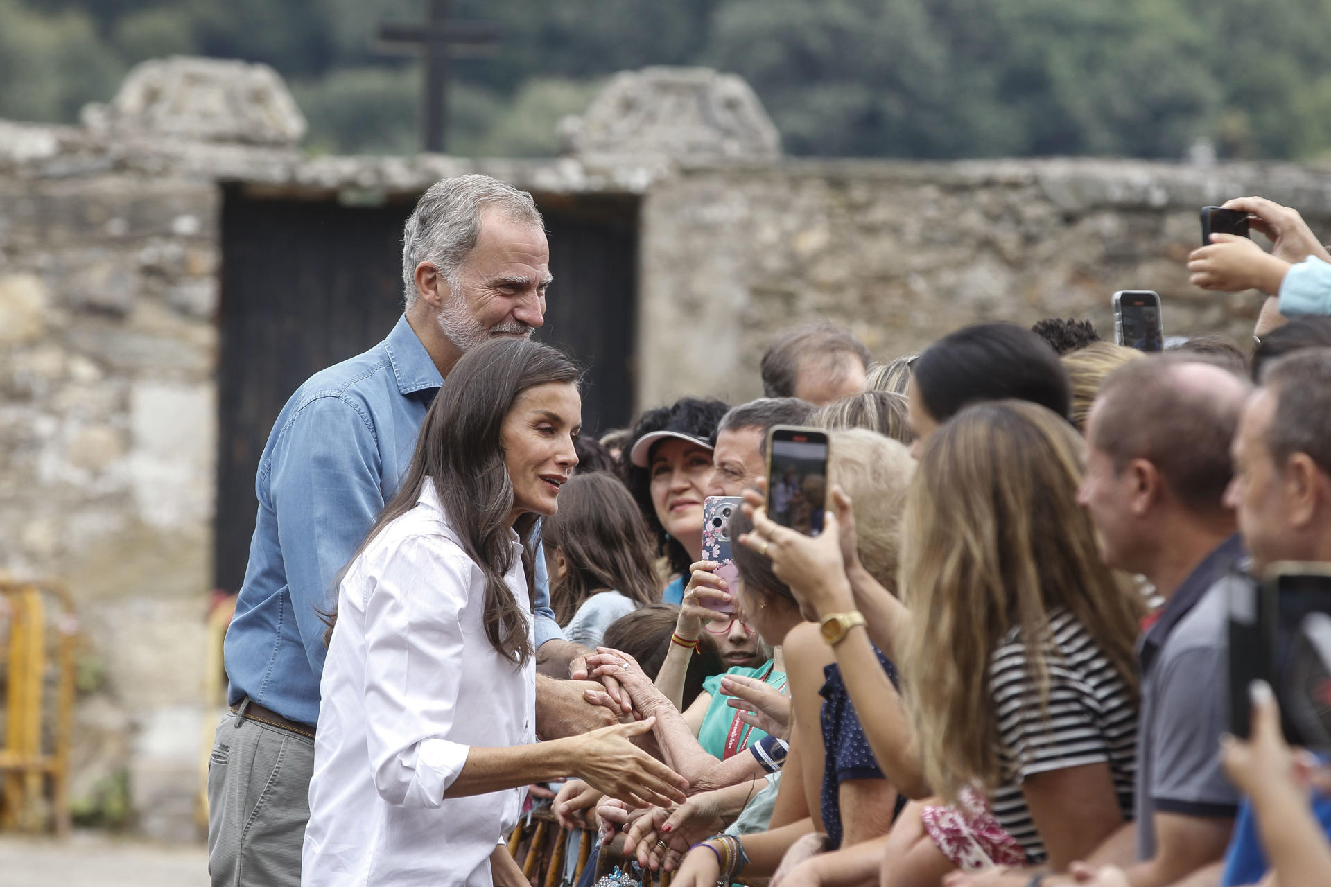 Los reyes Felipe Vi y Letizia saludan a las personas congregadas durante su visita a San Martin de Castañeda (Zamora) una de las zonas afectadas por los incendios forestales en esta provincia. EFE/Mariam A. Montesinos