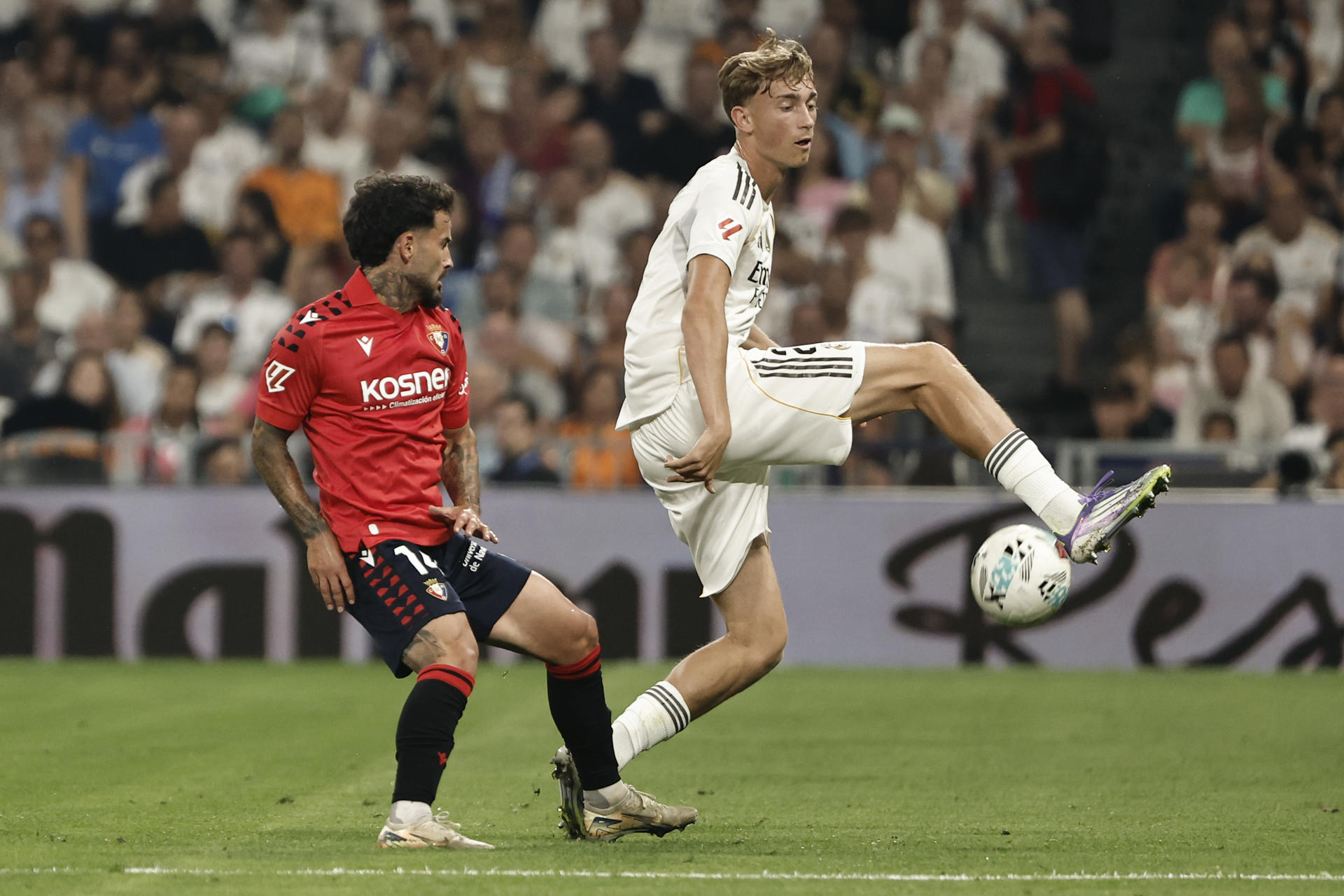 El defensa neerlandés del Real Madrid Dean Huijsen (d) despeja un balón ante Rubén García, de Osasuna, durante el partido de la primera jornada de LaLiga que Real Madrid y Atlético Osasuna disputaron en el estadio Santiago Bernabéu. EFE/SERGIO PÉREZ