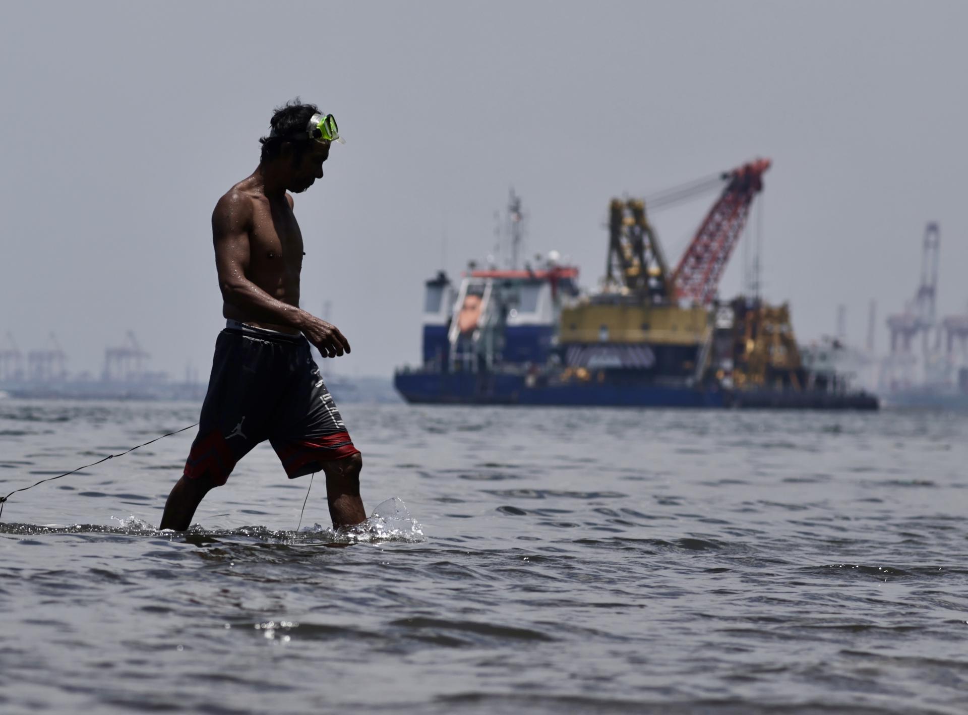 MANILA (Philippines), 19/08/2025.- A fisherman catches crabs and shells near a reclamation site in Manila Bay, Philippines, 19 August 2025. Philippine President Ferdinand Marcos Jr. ordered a suspension of all Manila Bay reclamation projects in 2023, though some later resumed after compliance approval. Fisherfolk and environmental groups, including Pamalakaya, have renewed calls for the Department of Environment and Natural Resources (DENR) to fully enforce the suspension, citing encroachment on fishing grounds, degraded marine resources, reduced catches, flooding, and loss of livelihood. (Filipinas) EFE/EPA/FRANCIS R. MALASIG