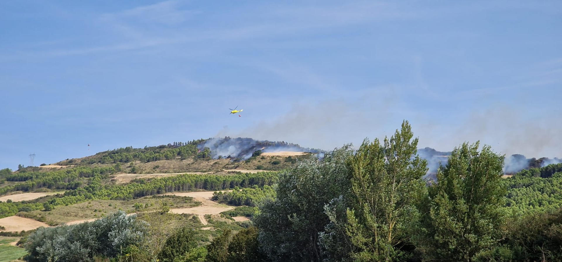 Los Bomberos de Navarra continúan trabajando en el incendio forestal declarado este martes en la zona de Obanos, un fuego que anoche quedó estabilizado y que ha contado con personal durante toda la noche para intentar controlarlo, en tareas a las que se les ha relevado esta madrugada con efectivos por tierra y aire. Según SOS Navarra, a las 07:30 horas cinco brigadas de Bomberos se han incorporado al dispositivo en la zona afectada realizando labores de remate y refresco. A ellos se han sumado a las 09:30 horas los medios aéreos, que realizarán descargas en los puntos calientes.-EFE/Gobierno Navarra ***SOLO USO EDITORIAL/SOLO DISPONIBLE PARA ILUSTRAR LA NOTICIA QUE ACOMPAÑA (CRÉDITO OBLIGATORIO)***