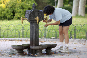 Una mujer se refresca en una fuente, este viernes en Madrid. Una nueva ola de calor azotará previsiblemente desde este domingo gran parte de la península, especialmente el centro y la mitad sur, hasta al menos el próximo martes, cuando se espera "el día más caluroso del episodio", con temperaturas que podrían rondar los 44 grados en algunos casos. EFE/ Mario Moron