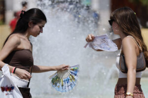 Dos mujeres se refrescan este martes en el centro de Valencia.  EFE/Ana Escobar