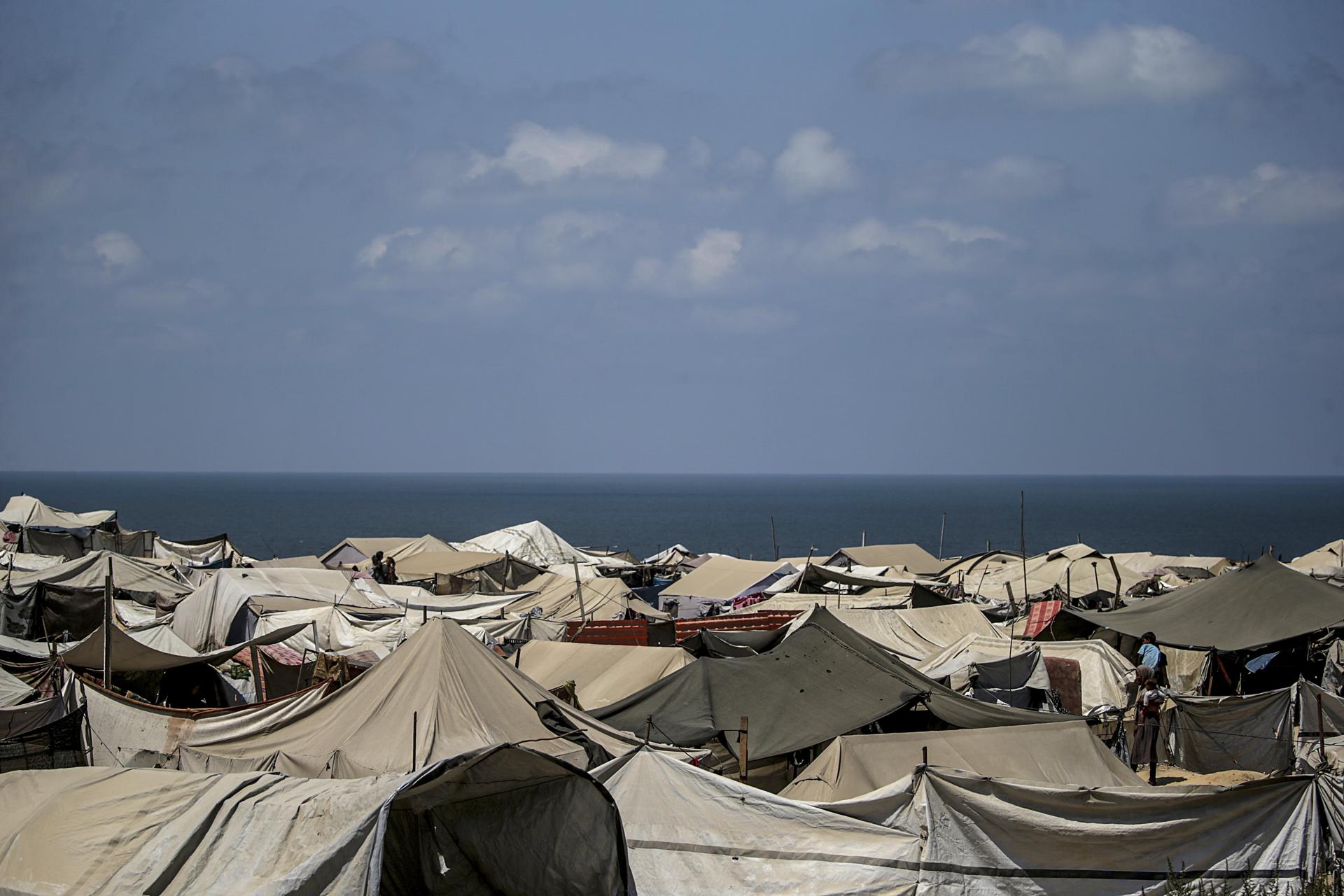 Carpas de palestinos desplazados internamente, que huyeron del este de la ciudad de Gaza y del norte de Gaza, cerca de los escombros de edificios destruidos en el oeste de la Franja de Gaza Norte. EFE/MOHAMMED SABER