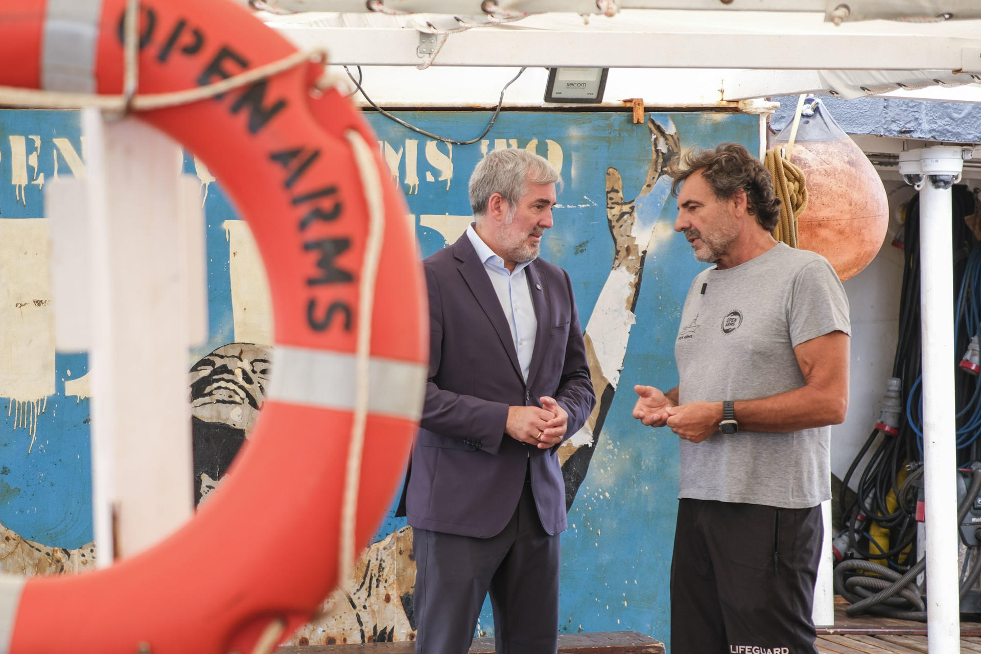El presidente de Canarias, Fernando Clavijo (i), y el presidente y fundador de la ONG Open Arms, Óscar Camps (d), durante su visita de este jueves al buque de la ONG, en el puerto de Santa Cruz de Tenerife, donde anunciaron que el Open Arms permanecerá en Canarias durante dos meses para realizar una campaña de concienciación sobre el drama de la ruta atlántica de inmigración como respuesta a "discursos xenófobos" y para "recuperar un poco esa humanidad que parece que estamos perdiendo". EFE/Alberto Valdés