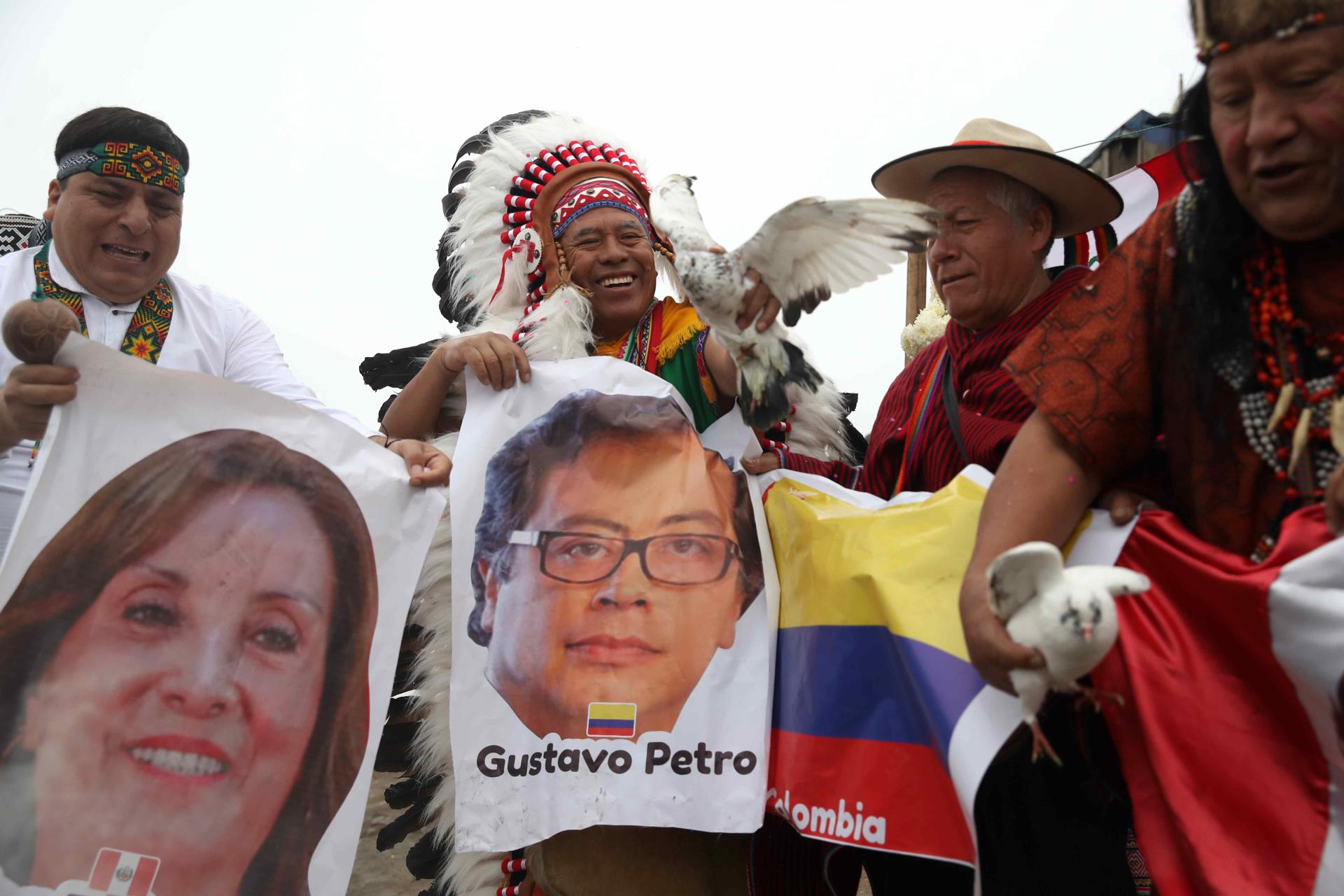 Chamanes peruanos sostienen carteles con la imagen del presidente de Colombia, Gustavo Petro, y la presidenta de Perú, Dina Boluarte, durante una ceremonia este lunes, en el cerro San Cristóbal en Lima (Perú). EFE/ Paolo Aguilar
