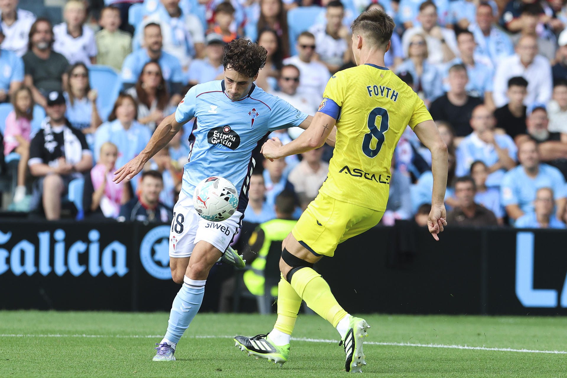 El delantero del Celta de Vigo Pablo Durán (i) pugna por un balón con el defensa argentino del Villarreal Juan Foyth en el partido de LaLiga disputado este domingo en el estadio Balaidos de Vigo. EFE / Salvador Sas